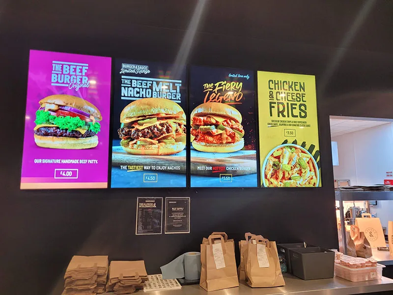Digitale Menüboards über der Theke in einem Burger-Restaurant