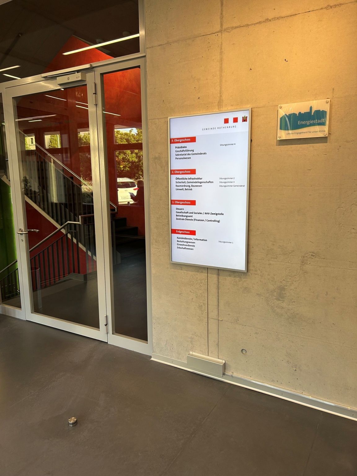 Digitales Informationsdisplay neben dem Treppenaufgang der Gemeinde
